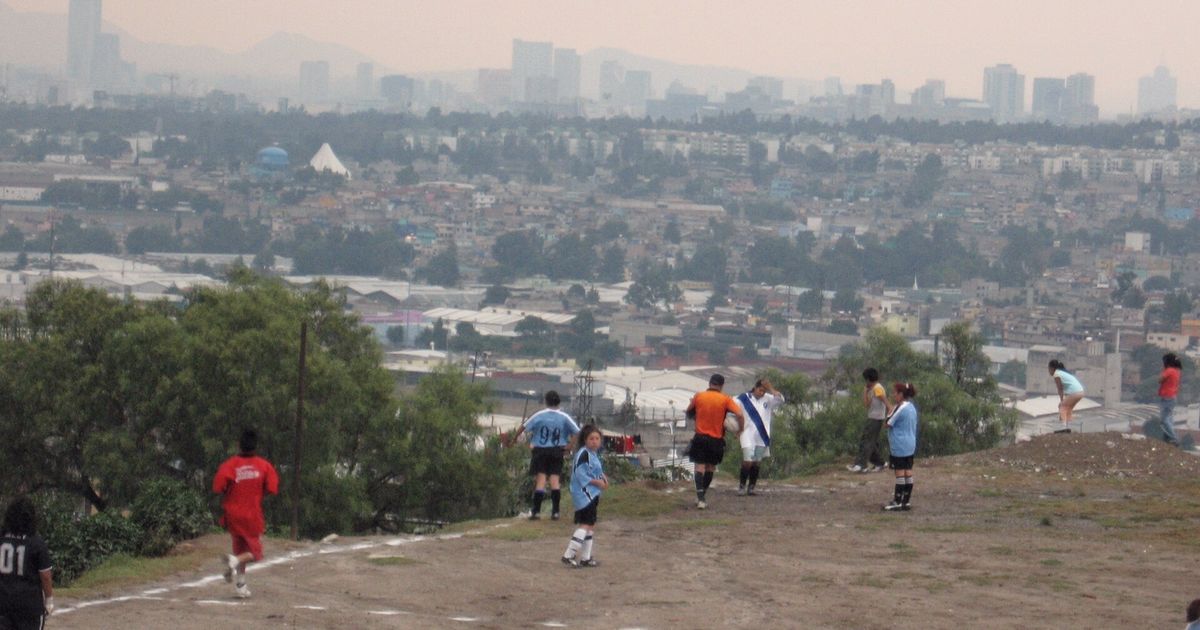 Cancha de tierra en un cerro con la ciudad al fondo