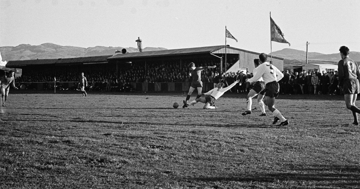 Fotografía antigua en blanco y negro de una jugada junto a la tribuna