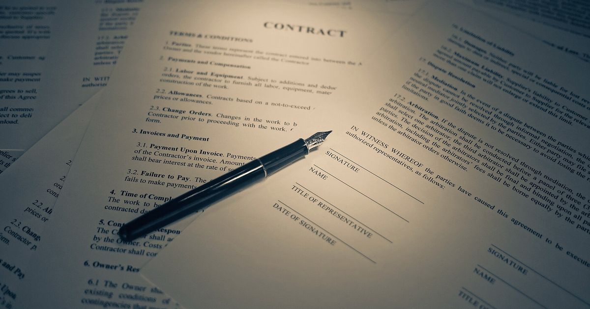 Contrato sobre una mesa con una pluma estilográfica