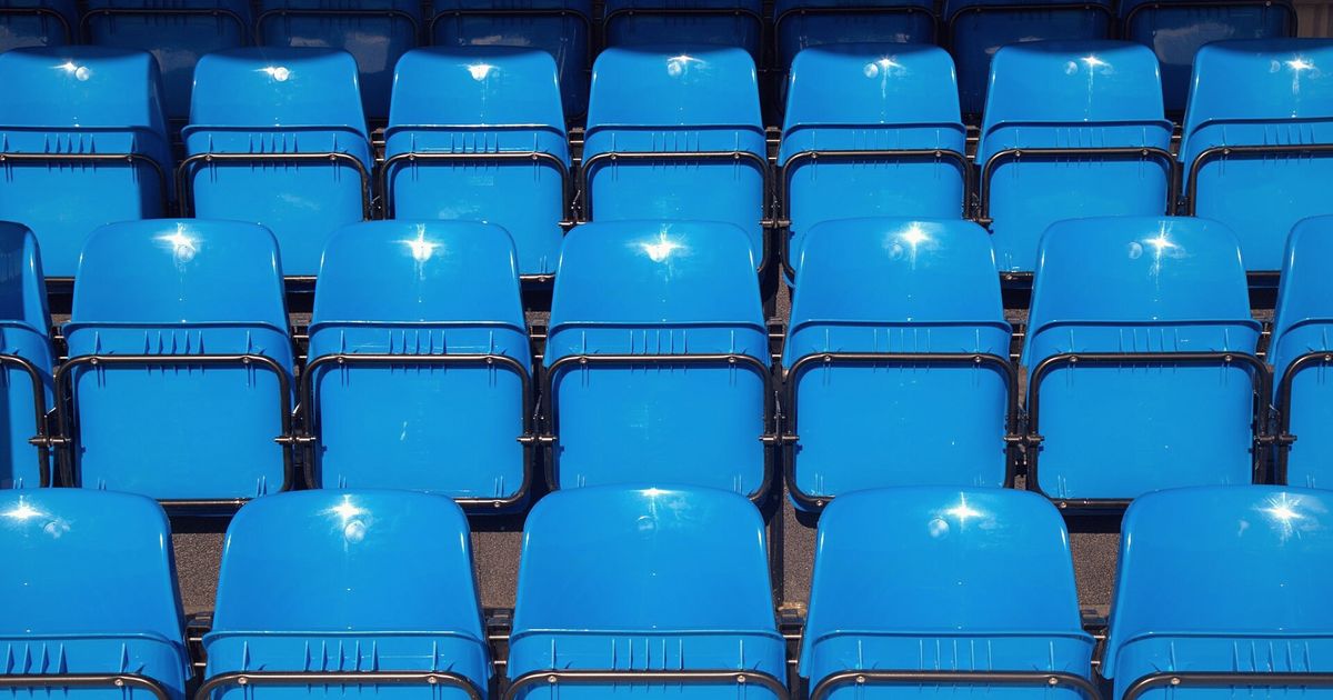 Filas de asientos azules vacíos en un estadio
