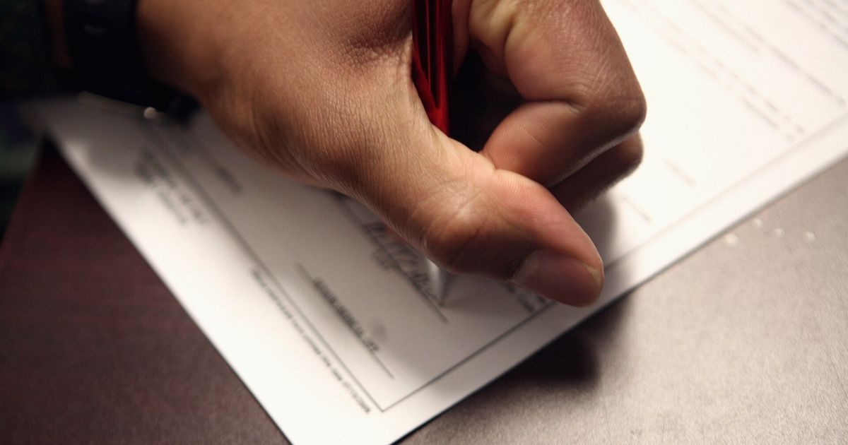 Mano firmando un documento con un bolígrafo